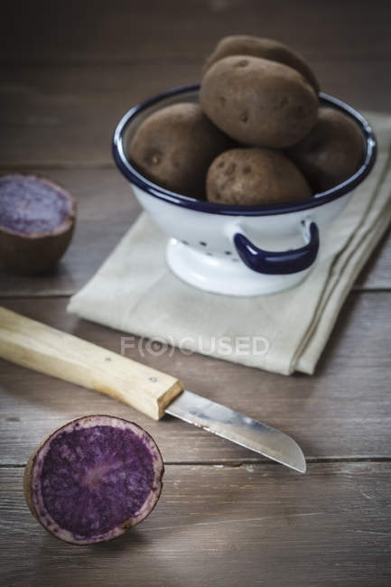 Whole and halved Blue Congo potatoes — Stock Photo