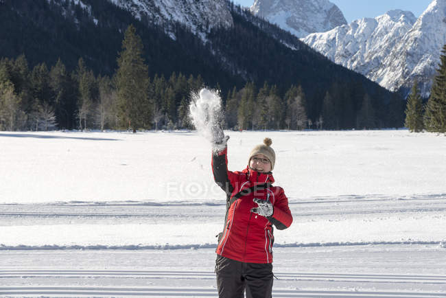 Austria, Tirolo, Pertisaù, giovane donna che lancia palla di neve — Foto stock