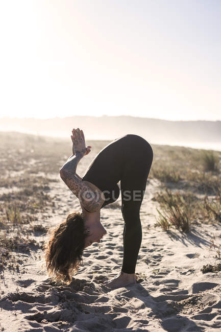 Spain, Asturias, Aviles, woman practicing yoga on the beach — Stock Photo