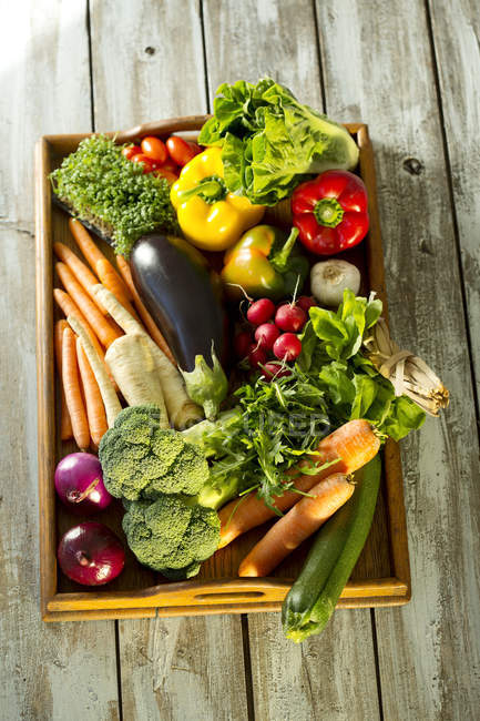 Wooden tray with different vegetables, top view — Stock Photo