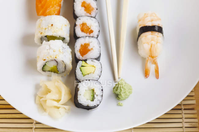 Variedad de sushi con wasabi y jengibre en plato - foto de stock
