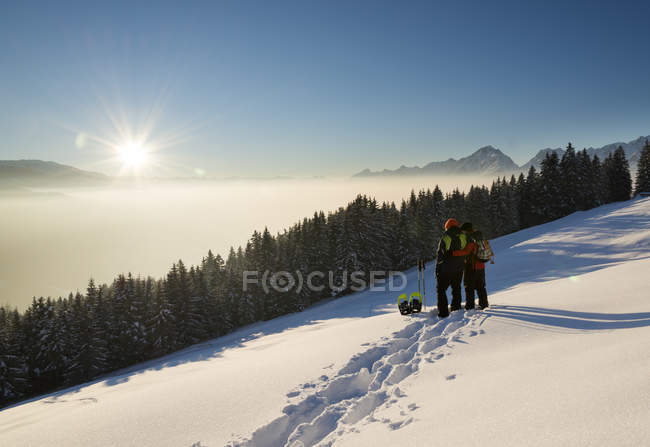 Austria, Tyrol, Schwaz, couple with snowshoes looking at view — Stock Photo