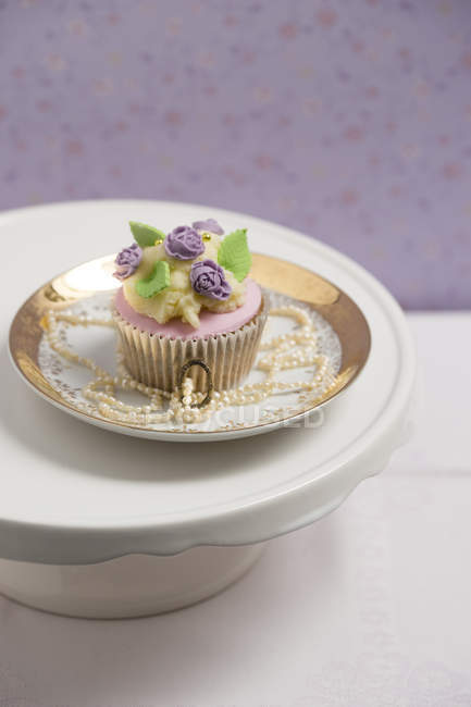 Cupcake con fondant de flor de rosa y crema de mantequilla - foto de stock