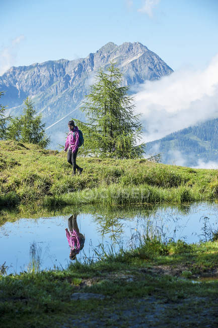 Austria, Altenmarkt-Zauchensee, giovane donna che fa escursioni nel paesaggio alpino — Foto stock