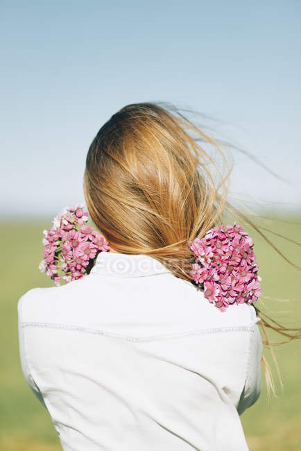 Visão traseira da mulher com flores ao ar livre — Fotografia de Stock