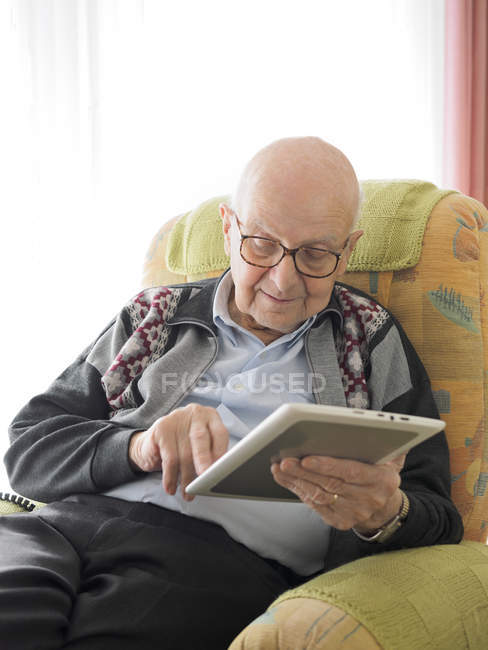 Старий в домашніх умовах використовуючи цифровий планшетний — стокове фото