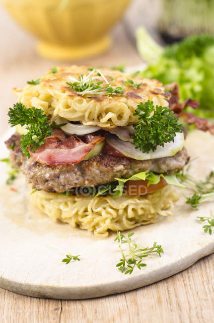 Close-up of Ramen burger with meat and fresh vegetables on wooden board — Stock Photo
