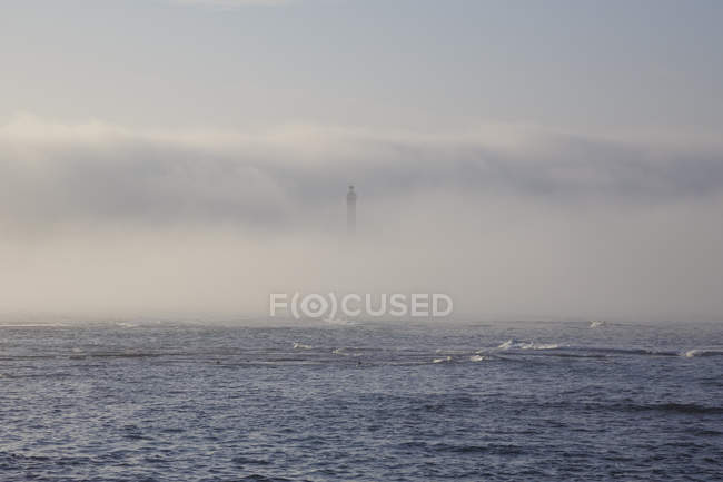Маяк на березі моря в тумані — стокове фото