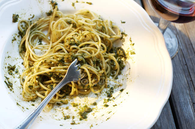 Forchetta in piatto di spaghetti servita con pesto di basilico — Foto stock