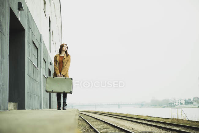 Mujer joven con maleta en la plataforma — Stock Photo