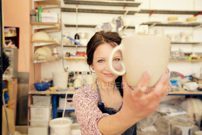 Ritratto di ceramista sorridente in una brocca da studio — Foto stock