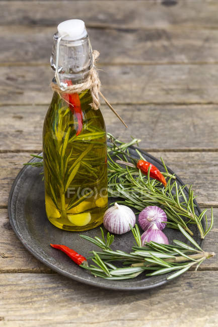 Rosemary Oil In Bottle, Garlic, Rosmary And Chilli Peppers On Plate 