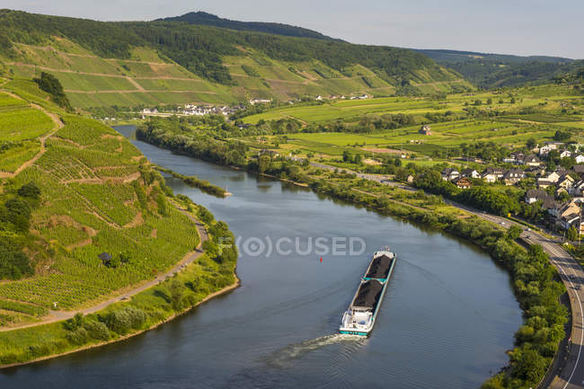 Германия, Рейнланд-Пфальц, долина Мозель, грузовое судно, проходящее Бремм — стоковое фото