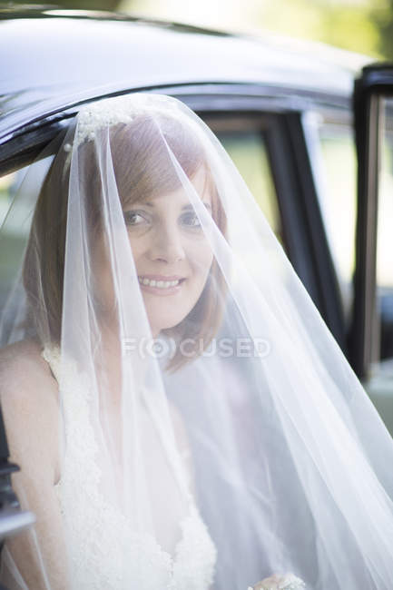 Sposa sorridente uscire dalla macchina prima del suo matrimonio — Foto stock