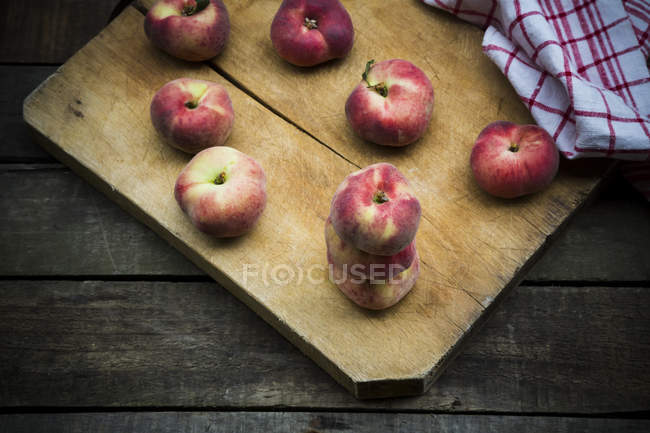 Персики на деревянной доске — стоковое фото