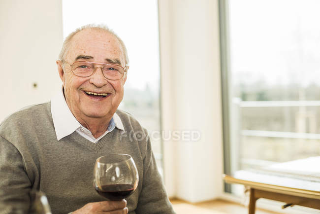 Ritratto di anziano sorridente con bicchiere di vino rosso — Foto stock
