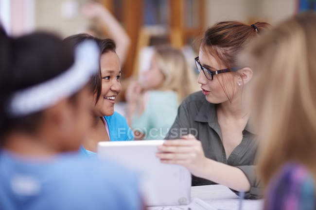 Teacher and smiling schoolgirls with digital tablet — Stock Photo