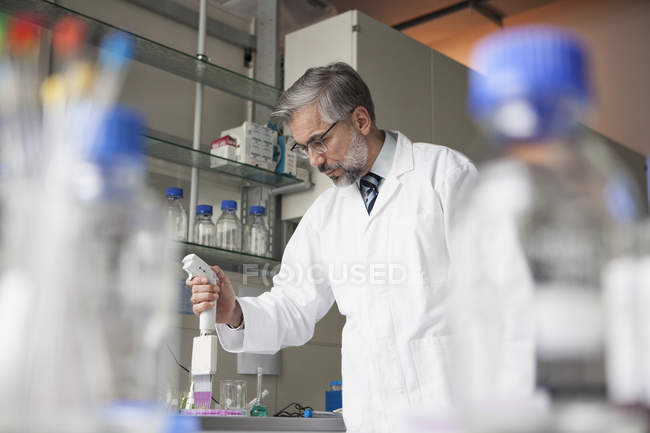 Pipeteo científico en laboratorio - foto de stock