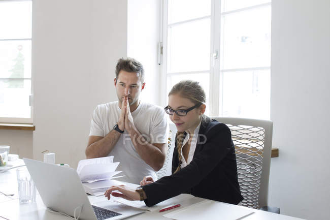 Junge Frau und Mann mit Laptop am Schreibtisch — Stockfoto