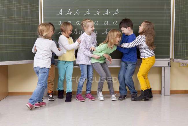 Playful pupils having fun in classroom — Stock Photo