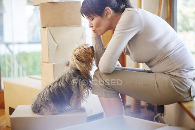 Femme déménageant partager un moment avec le chien — Photo de stock