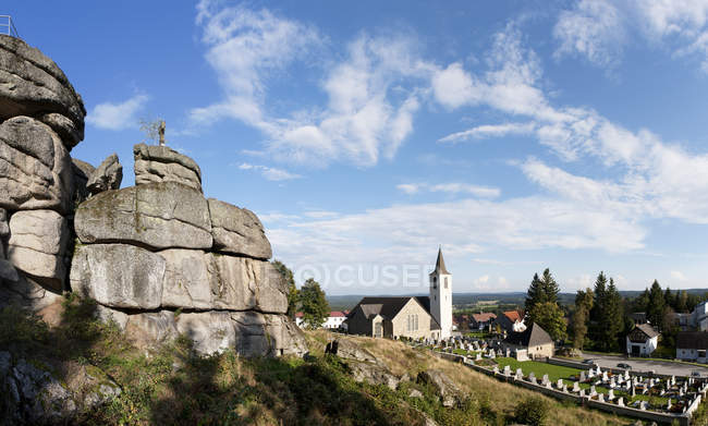 Austria, Waldviertel, Bad Traunstein, Iglesia parroquial con cementerio contra el cielo - foto de stock