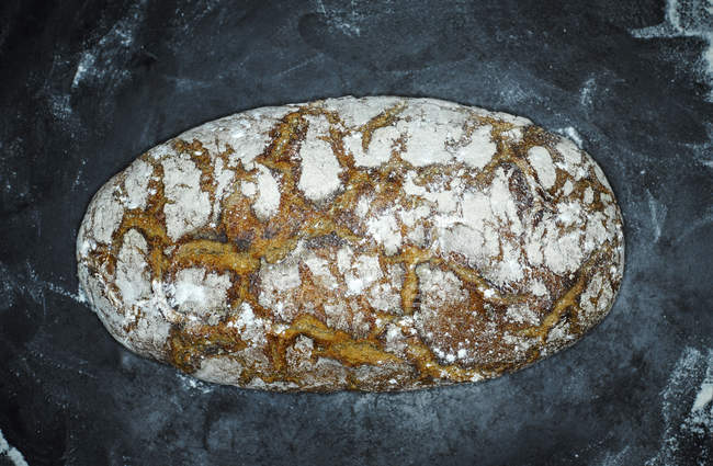 Pan crujiente en la superficie negra con harina — Stock Photo