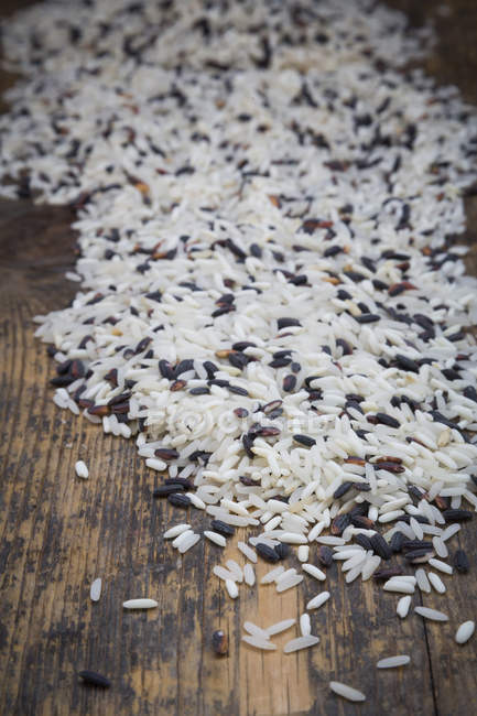 Organic basmati rice on dark wood — Stock Photo