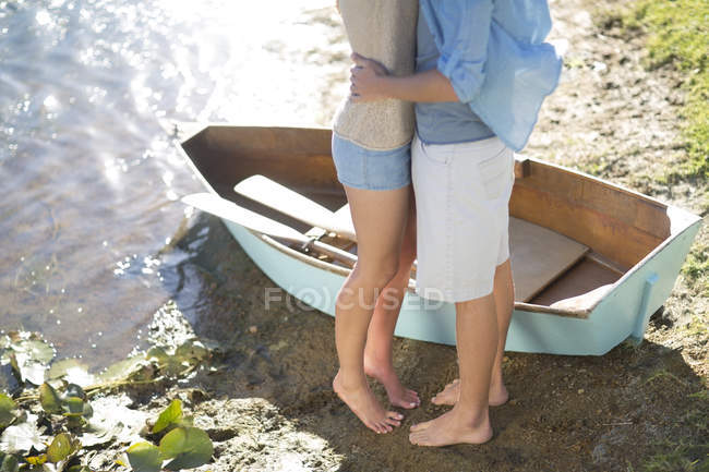 Jeune couple embrassant au bord du lac — Photo de stock