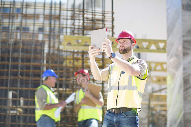 Travailleur de la construction avec tablette numérique sur le chantier — Photo de stock