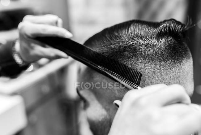 Friseur schneidet jungen Mann in Friseursalon die Haare — Stockfoto