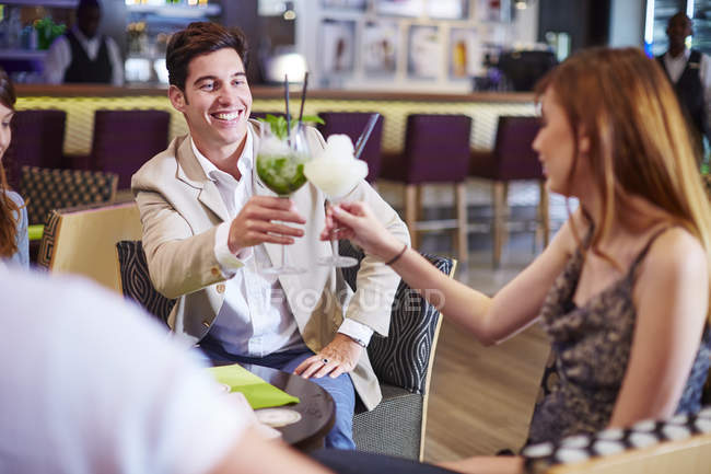 Man and woman clinking cocktail glasses at hotel bar — Stock Photo