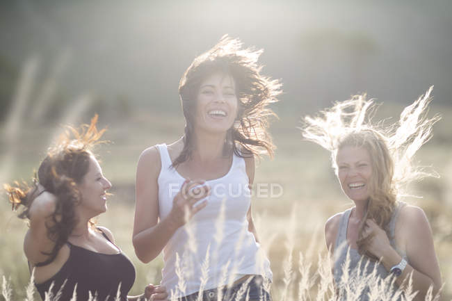 Amigas dançando e pulando em campo — Fotografia de Stock