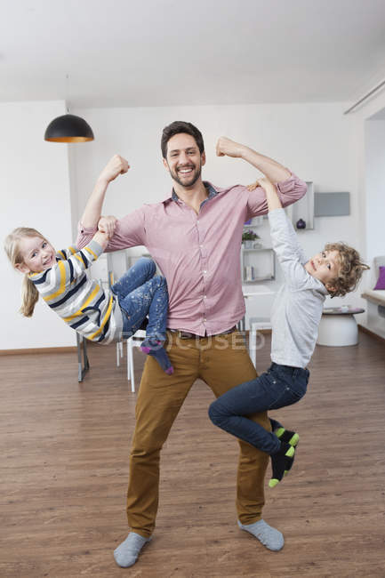 Padre llevando a hijo e hija en sus brazos — infancia, Tres personas -  Stock Photo | #180248960