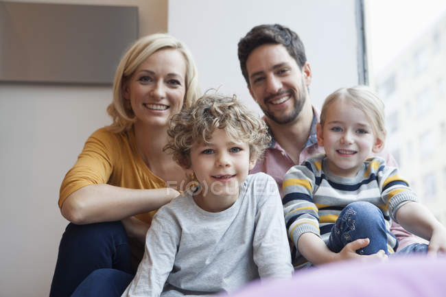 Portrait of happy family at the window — Stock Photo