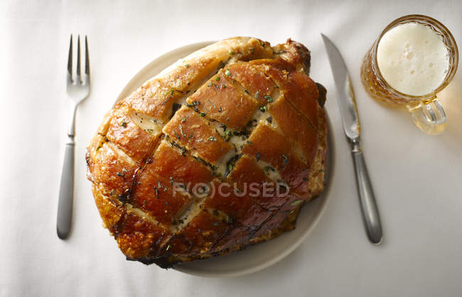 Plate of pork roast with crackling on laid table — Stock Photo