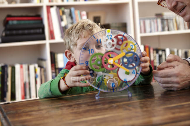 Boy playing with toy clock — Stock Photo