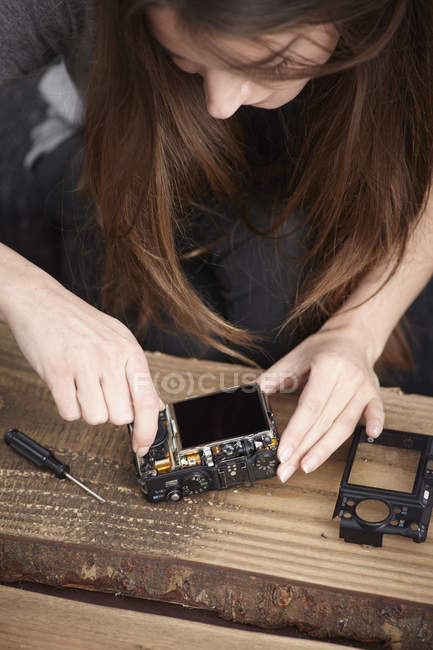 Giovane donna riparazione fotocamera — Foto stock