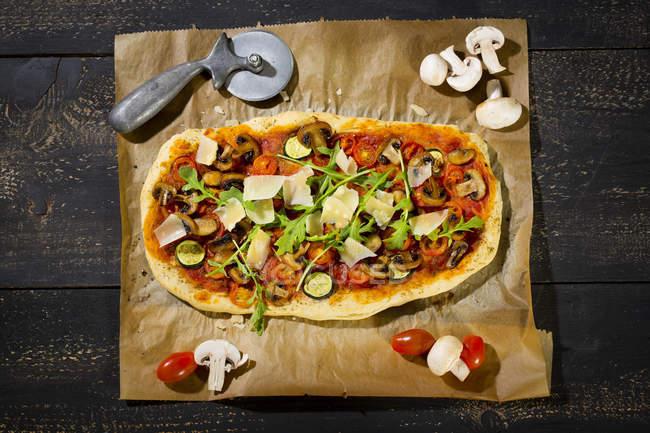 Homemade Pizza With Champignons Rocket Zucchini Tomatoes And Parmesan On Parchment Gourmet Garnished Stock Photo