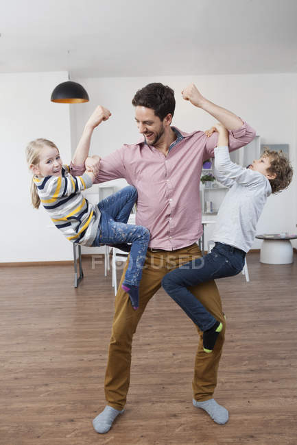 Padre llevando a hijo e hija en sus brazos — jugando, familia - Stock Photo  | #180254226