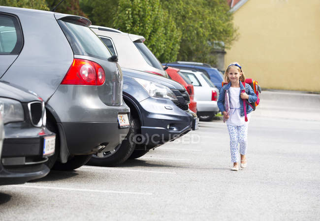 Bambina sulla sua strada scolastica attraversando parcheggio — Foto stock