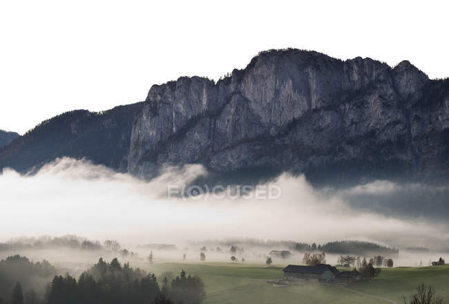 Áustria, Mondsee, Drachenwand na névoa da manhã contra rochas — Fotografia de Stock