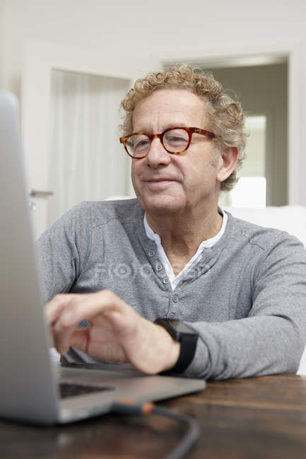 Hombre mayor usando portátil - foto de stock
