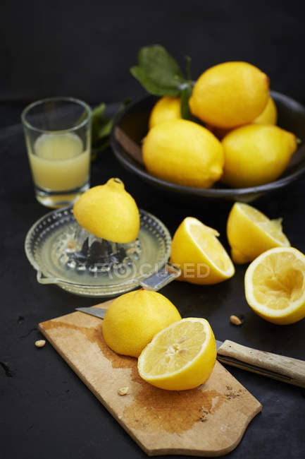Limones a la mitad con tabla de cortar - foto de stock