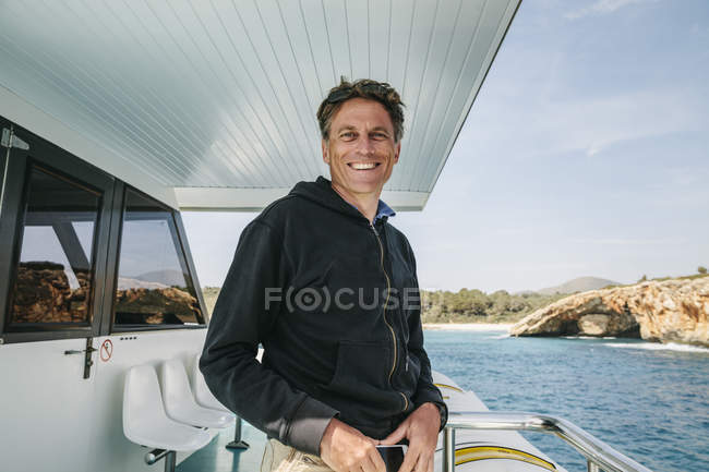 Ritratto di uomo sorridente in piedi su una barca — Foto stock