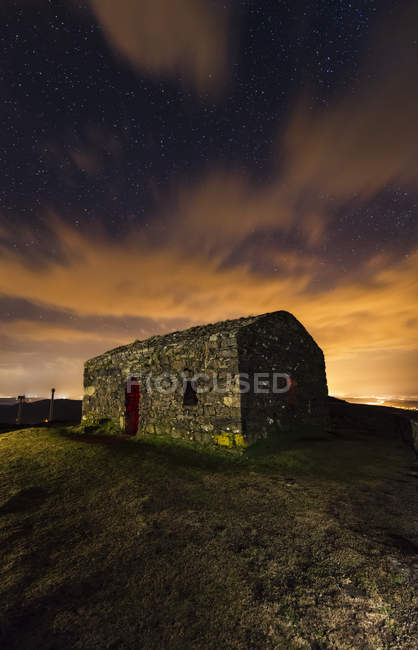 Spain, Galicia, Little abandoned building at night in Garita Herbeira under clouds — Stock Photo