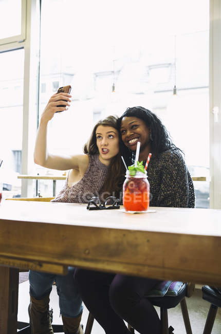 Zwei junge Frauen machen Selfie in einem Café — Stockfoto