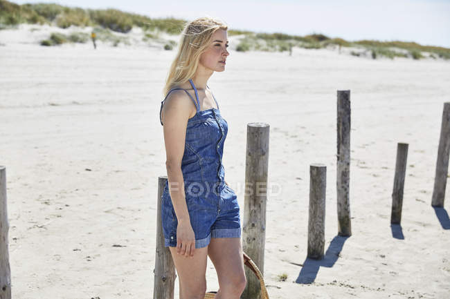 Giovane donna sulla spiaggia guardando da parte — Foto stock
