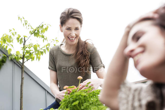 Счастливая молодая женщина с другом смеются на балконе — стоковое фото