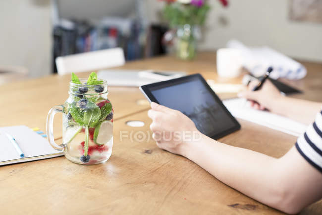 Nahaufnahme von Frauenhänden mit digitalem Tablet neben hausgemachter Limonade — Stockfoto
